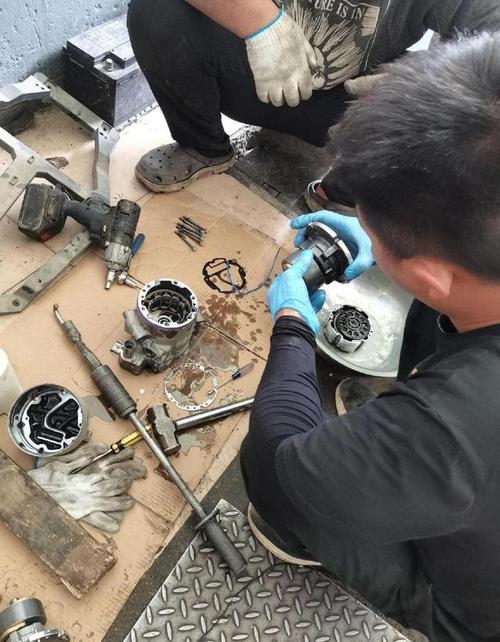 维修厂拆解汽车空调压缩机测量间隙场景图