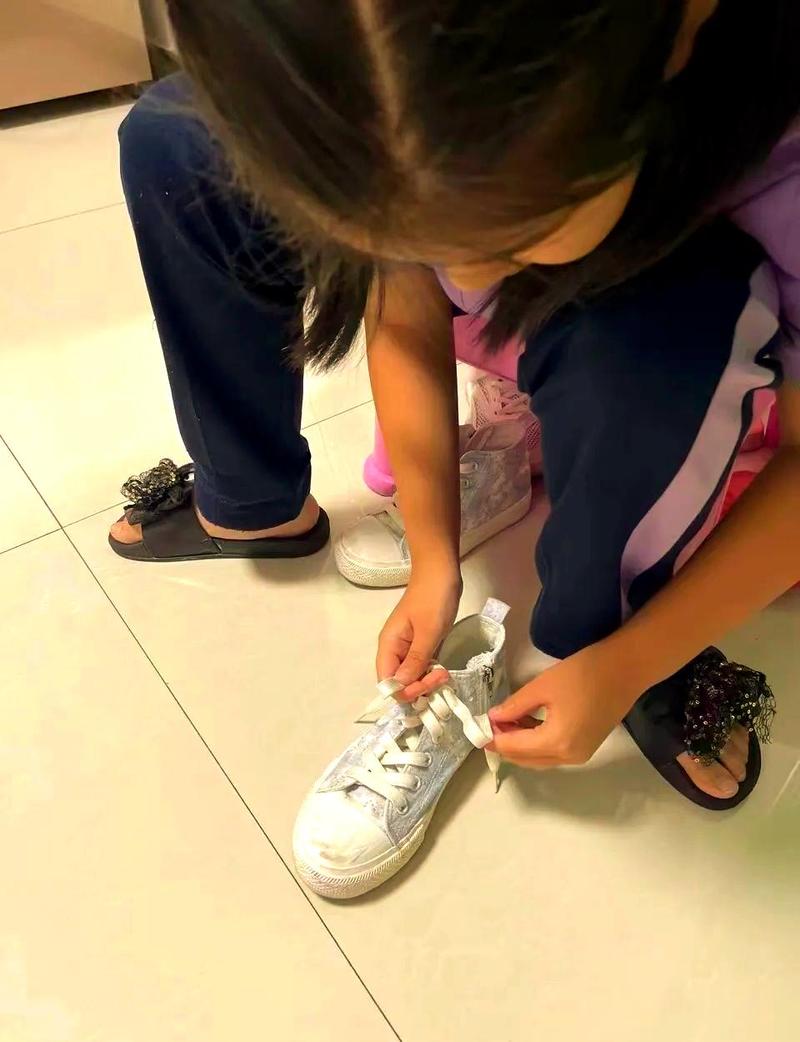 孩子笨拙系鞋带成功瞬间特写