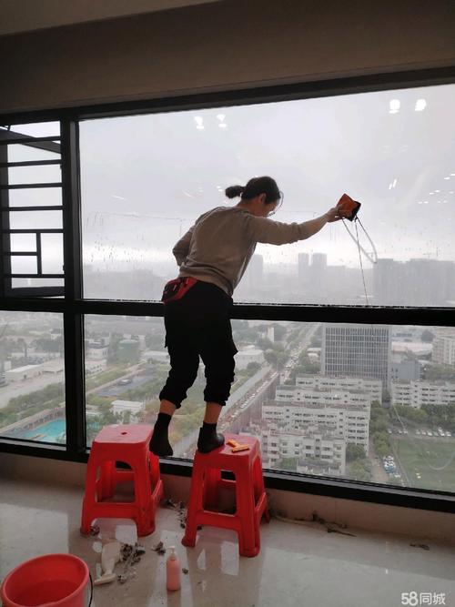 保洁工人使用铲刀清除窗框水泥残渣