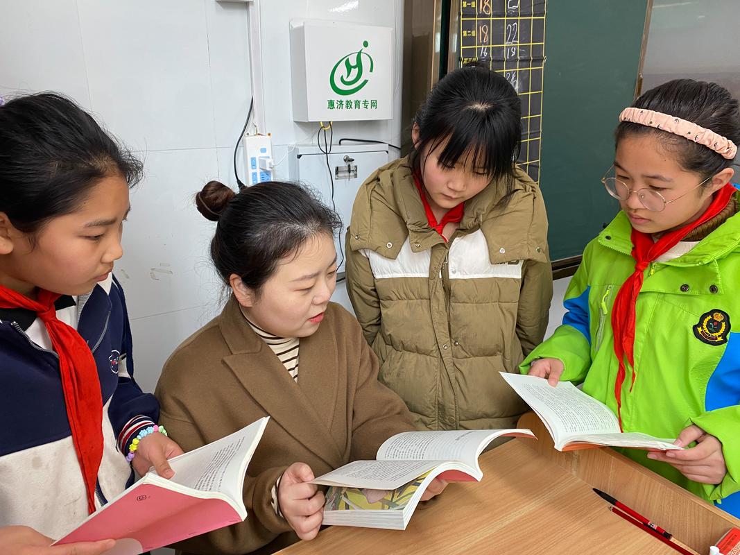 小学老师与学生课间交流阅读的温暖场景