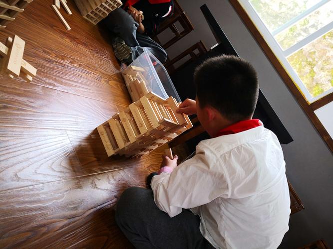 小学生教室积木搭斜面搬运人偶图