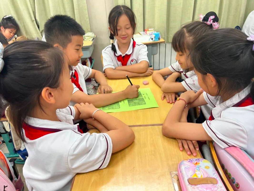 小学教室学生围坐拍手打节拍场景