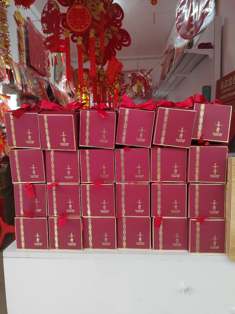 新娘崩溃看着一堆不满意的喜糖盒，婚礼倒计时，桌上杂乱堆放着红色烫金盒和丝带