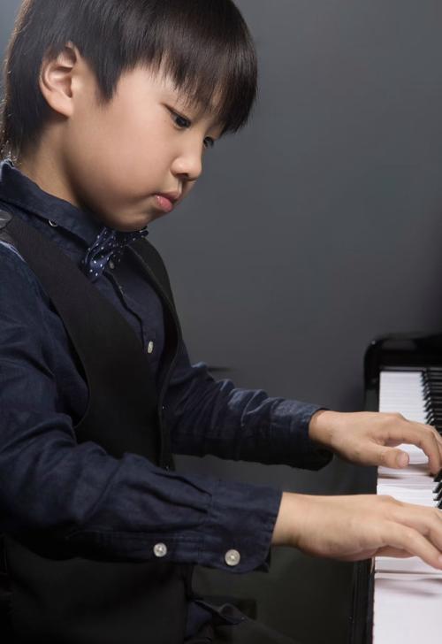 孩子机械弹钢琴表情木然