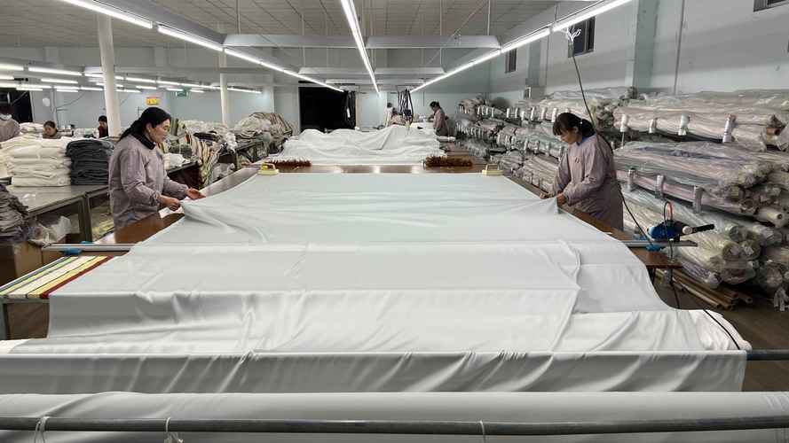 纺织工厂内工人正在裁剪瑜伽服弹力面料