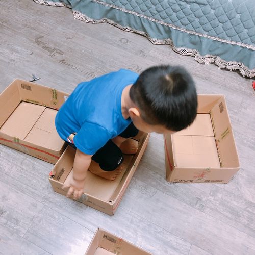 宝宝坐在地毯上玩快递纸箱做音乐启蒙