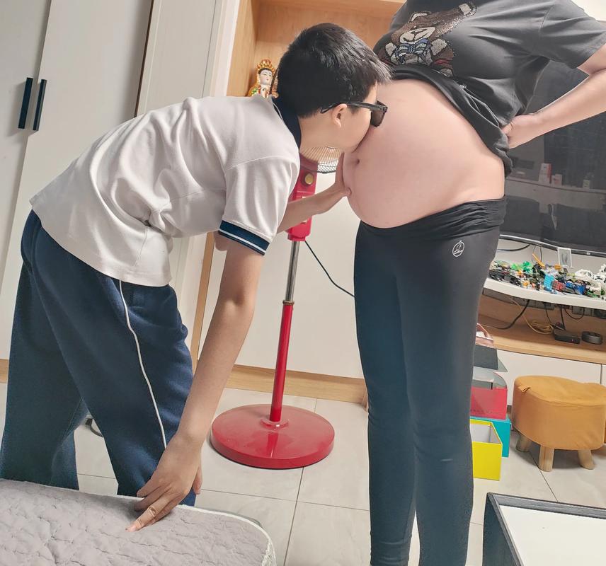 哥哥轻抚妈妈孕肚温馨特写
