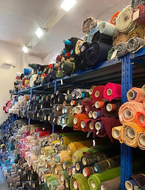 工厂直营服装门店靠墙堆放的整卷面料