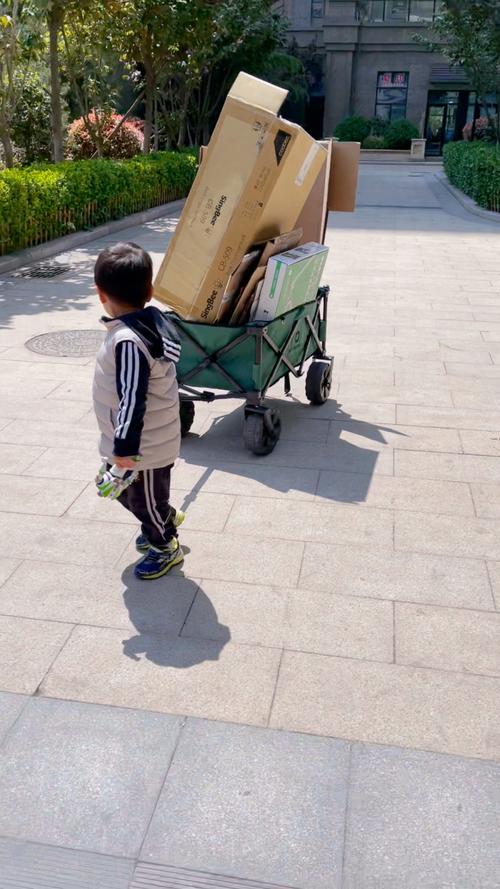 工业厂区门口小男孩拎保温桶等妈妈下班的实拍图