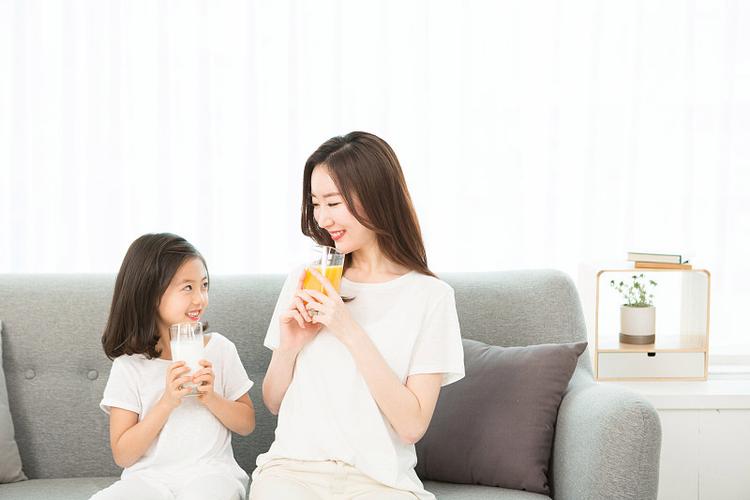 新手妈妈坐在客厅散落积木旁喝奶茶场景