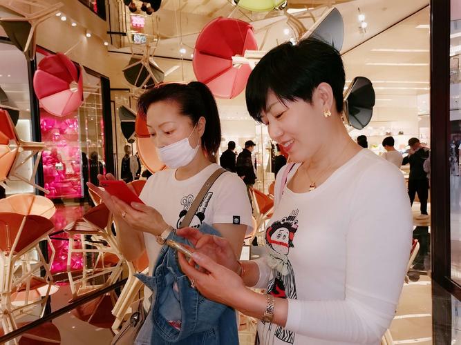 商场内路人举手机近距离拍摄他人正面场景实拍