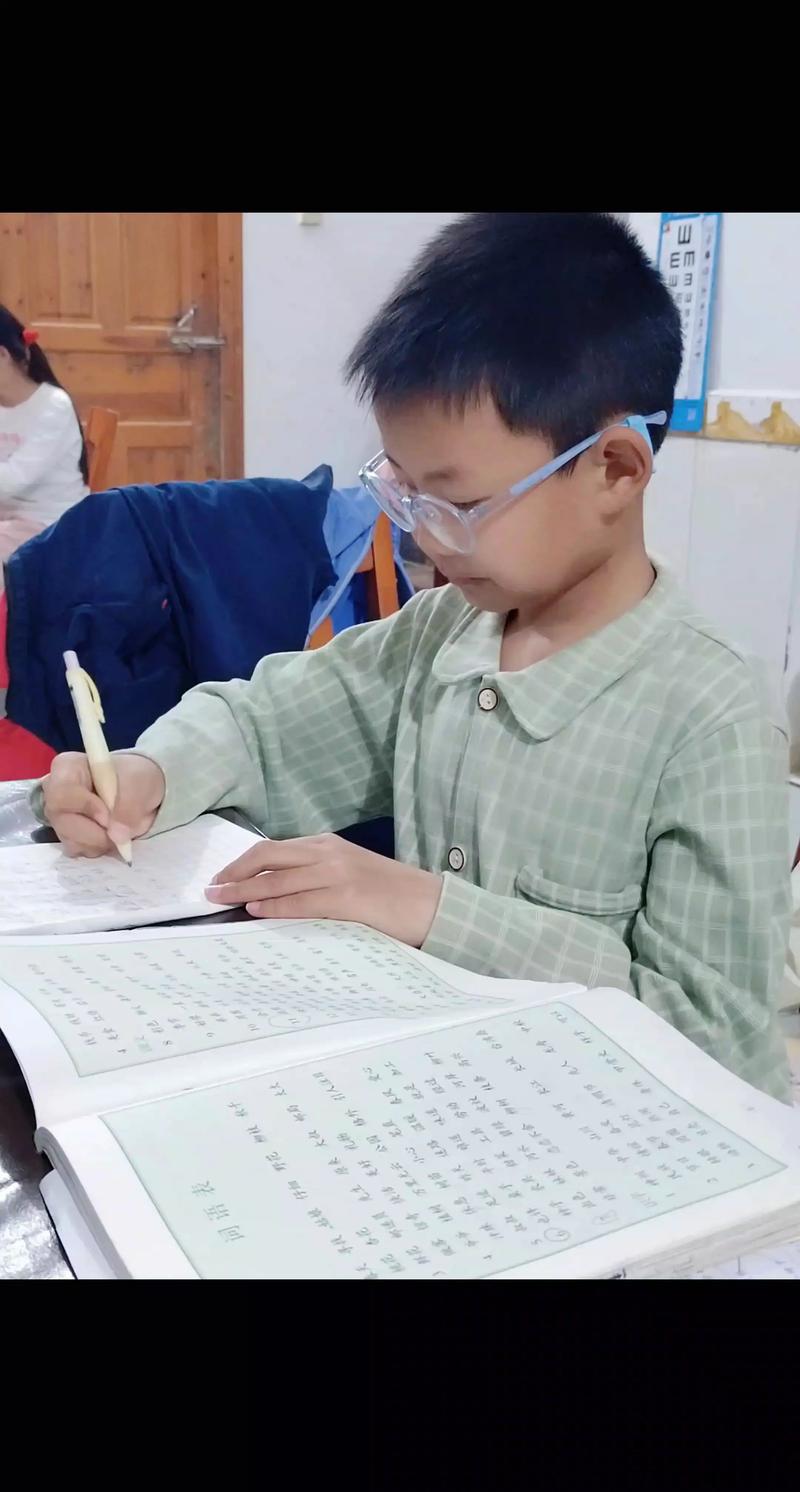 幼儿园孩子被迫坐在课桌前写拼音