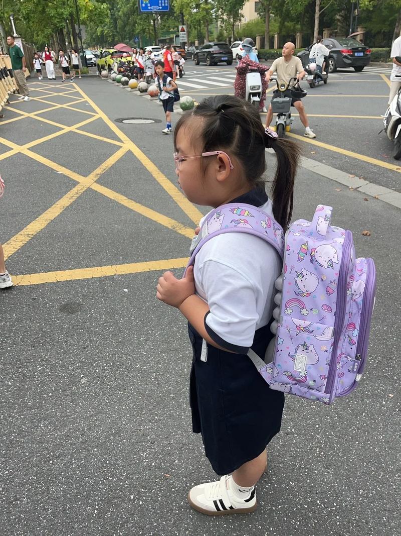 小女孩背书包唱歌走过斑马线阳光