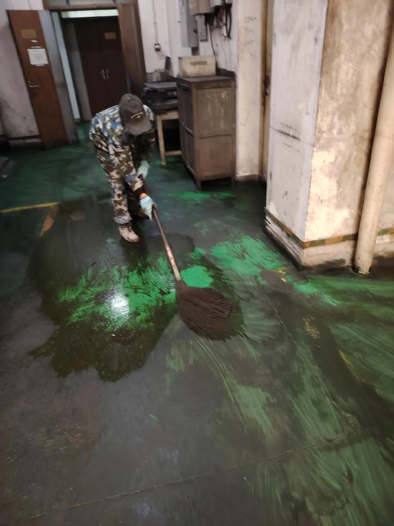 工厂车间内工人穿安全鞋踩在油污地面上