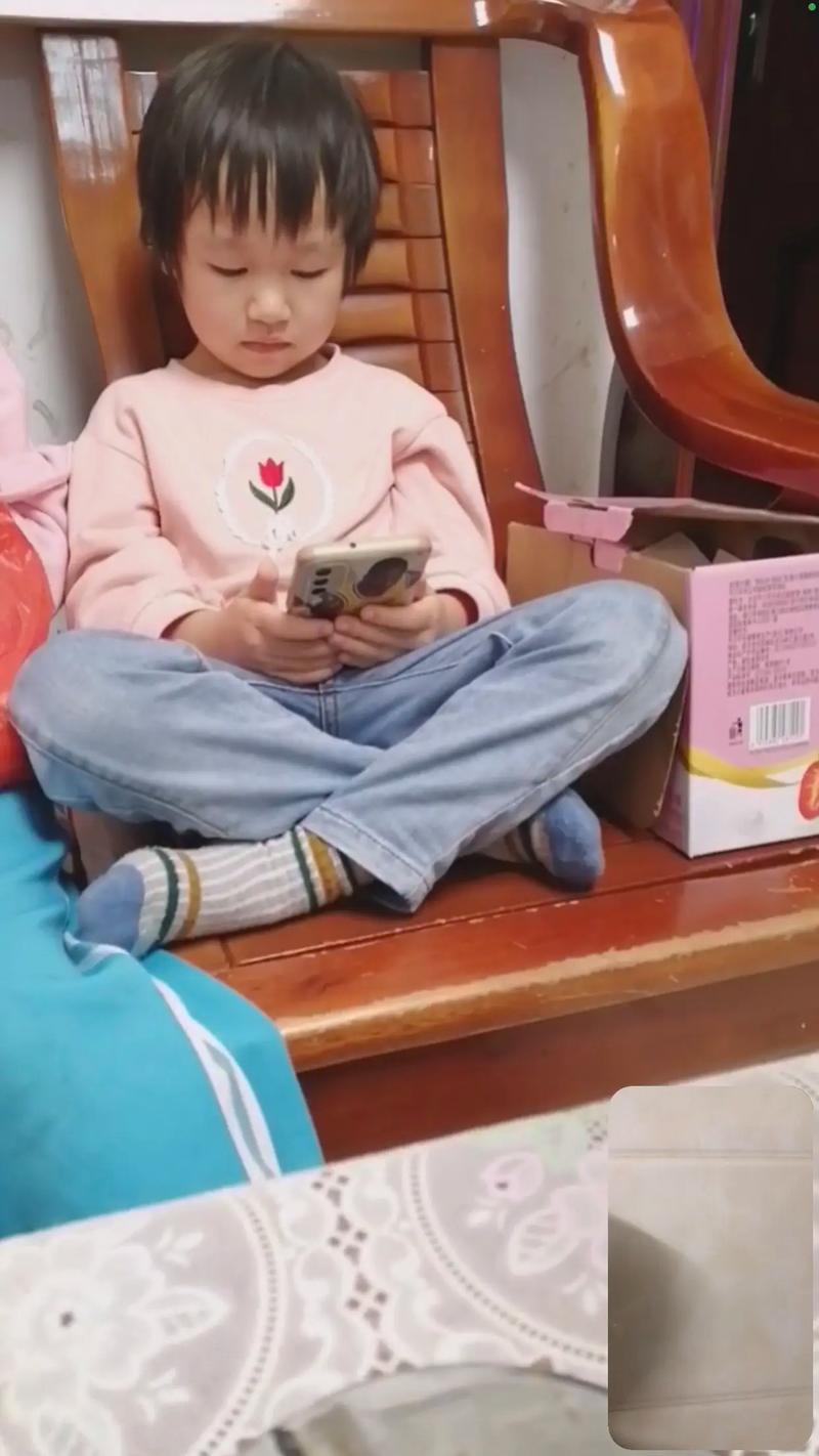 小女孩拿着玩具手机模仿大人打电话的亲子生活场景