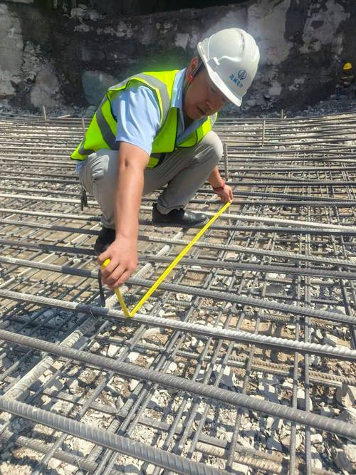 监理工程师在工地现场检查钢筋绑扎质量