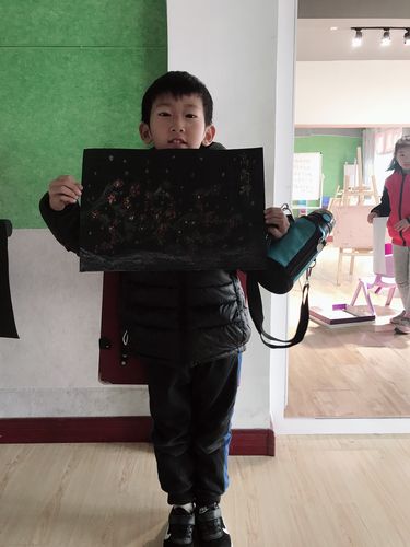 小学低年级孩子用蜡笔涂满黑色的画纸特写