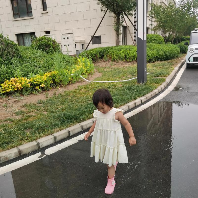 雨天妈妈陪孩子踩水坑亲子互动场景图
