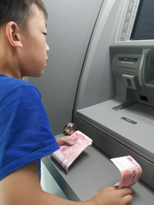 小学男孩攥着纸币在文具店柜台纠结