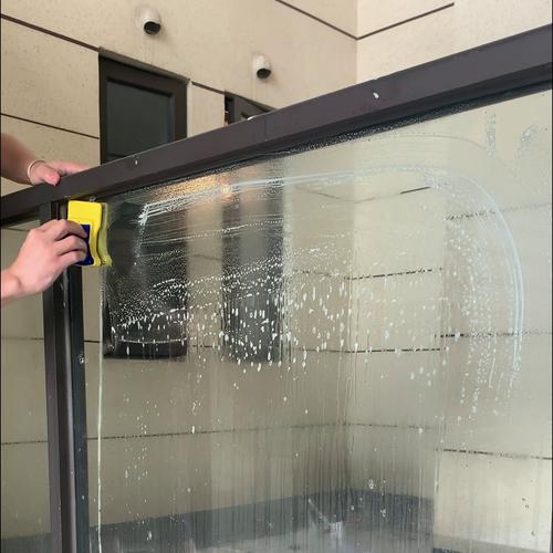 使用橡胶刮水板清洁玻璃窗不留水痕