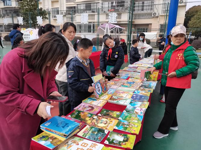 小学生在小区旧物置换摊点帮忙整理绘本