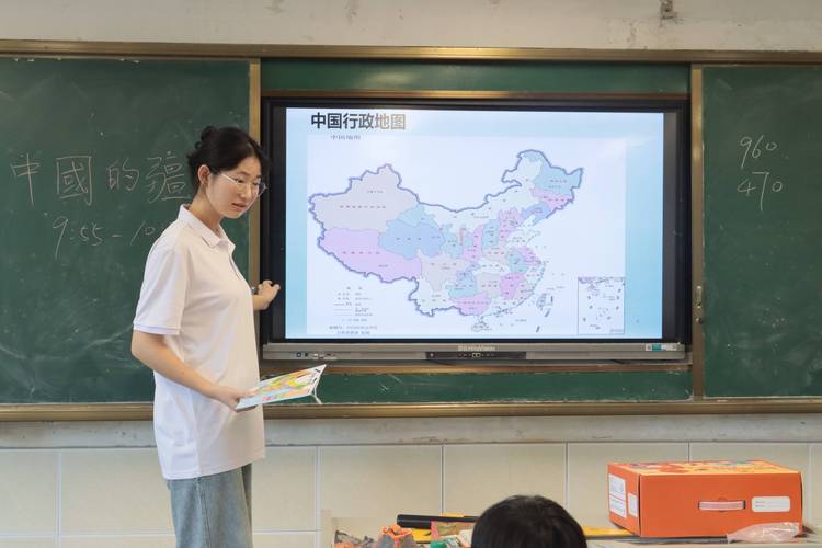 小学地理课堂上学生指着中国人口迁移分布图发言