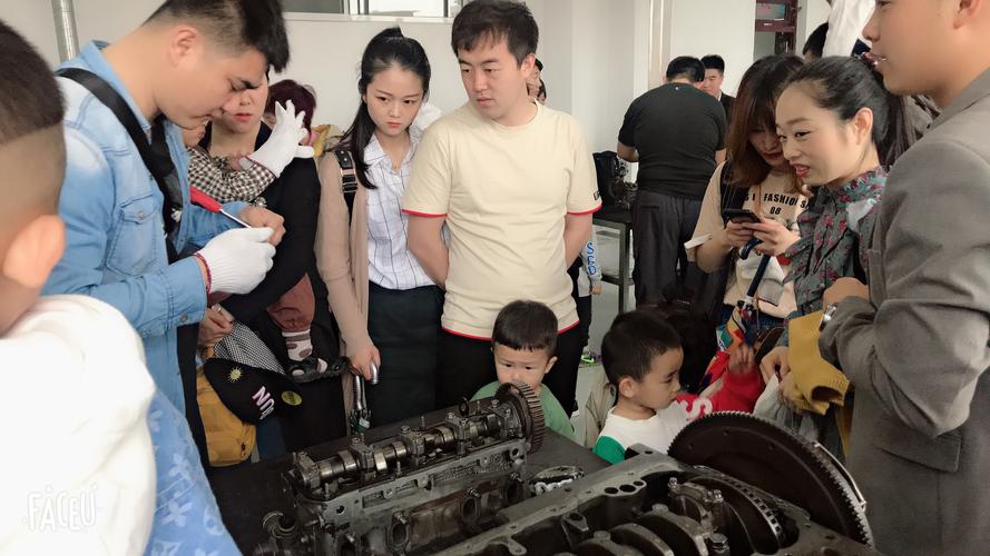 工业从业者给孩子讲解废弃合格汽车零件的亲子场景