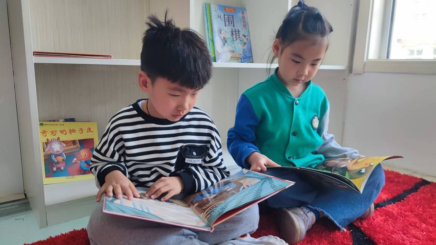 3岁幼儿坐在地毯上把绘本扔得满地的日常场景
