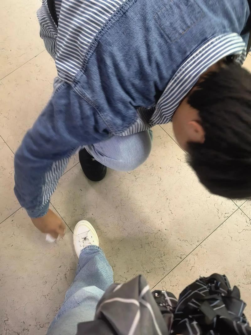 小孩蹲在玄关看家长鞋底提问生活场景