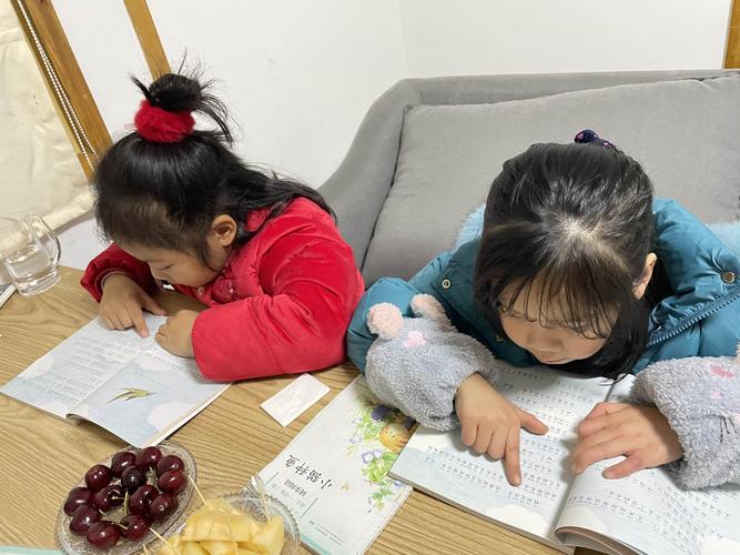 亲子围坐在书桌边玩诗句找茬游戏的温馨实拍图