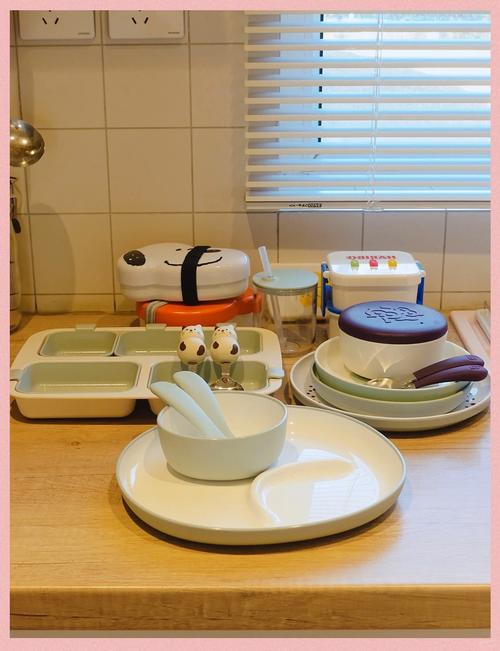 2岁儿童在厨房帮忙摆放食品级儿童餐具的实景