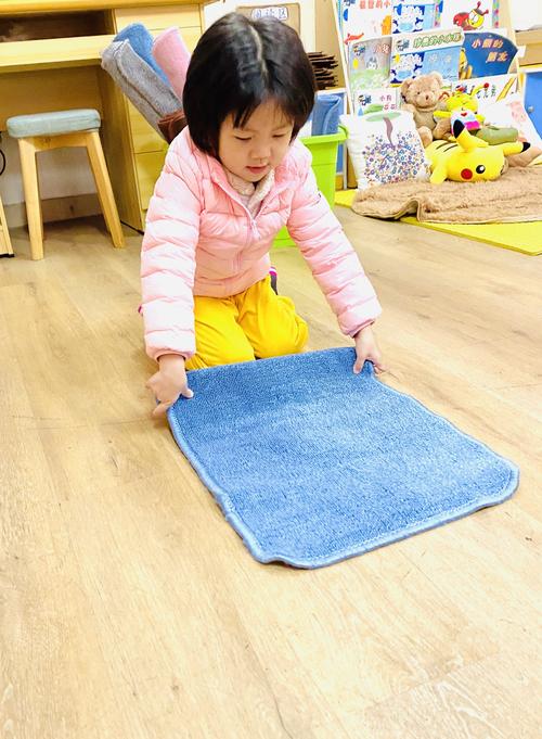 3岁幼儿紧紧抱着起球旧安抚巾蹲在客厅地板