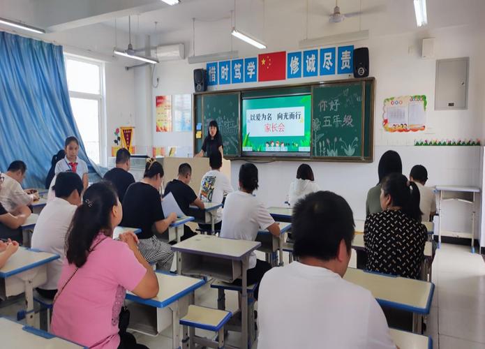 小学家长会现场老师和家长一对一交流的侧影