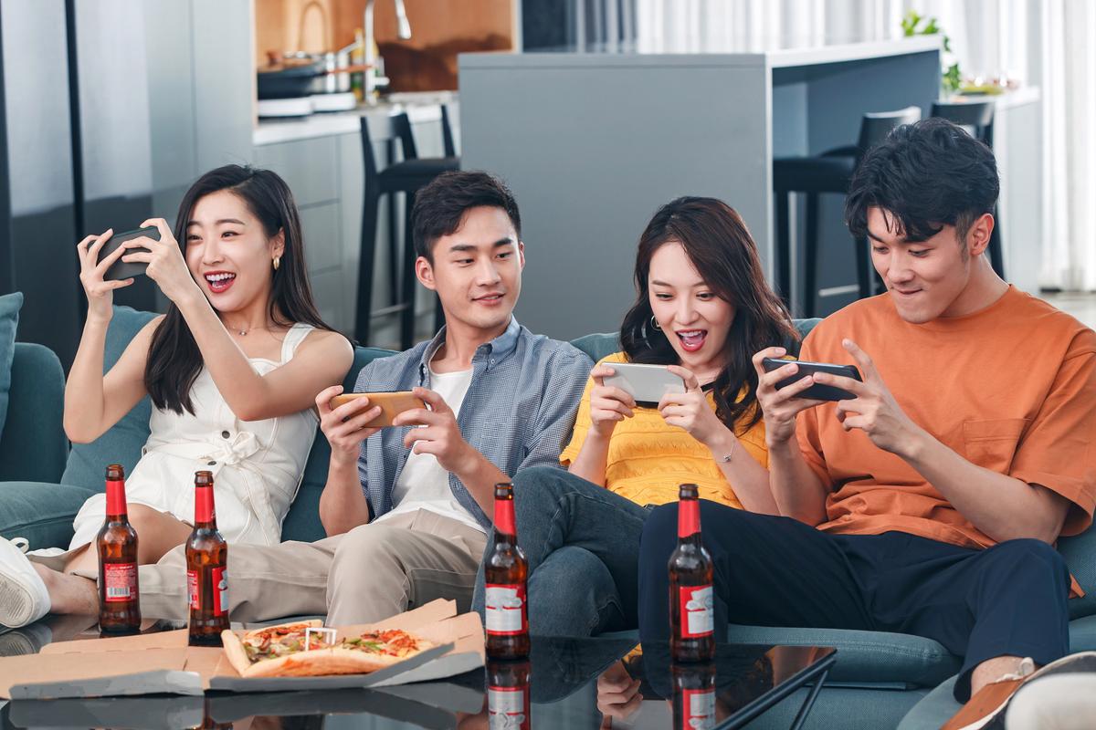 社交场合中年轻人使用手机玩梗的画面