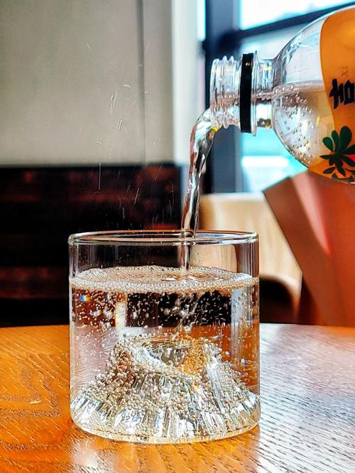 玻璃杯里倒入天然气泡矿泉水特写