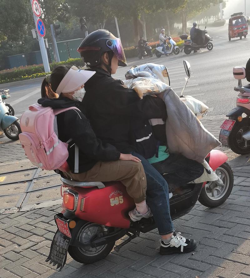 工业区家长骑电动车送娃上学哼歌场景