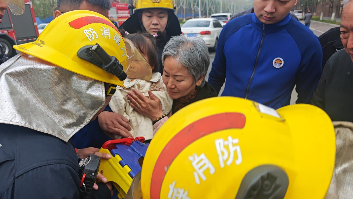 3岁幼童蹲在单元门消防栓旁用手指划墙上的汉字