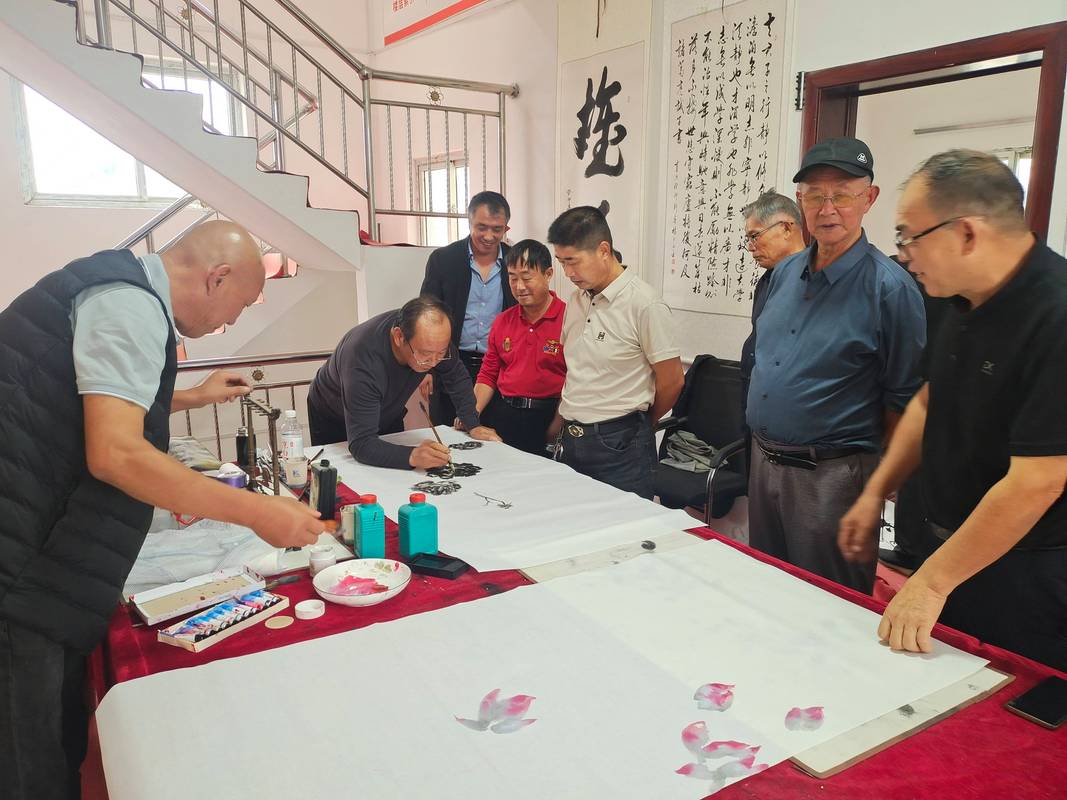 社区老年书画班老人共同看作品交流场景