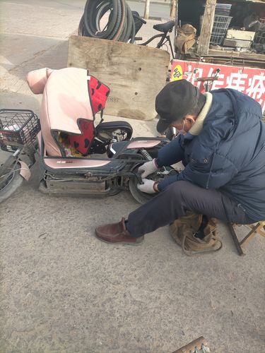 法院门口蹲着想事的年轻汽修工
