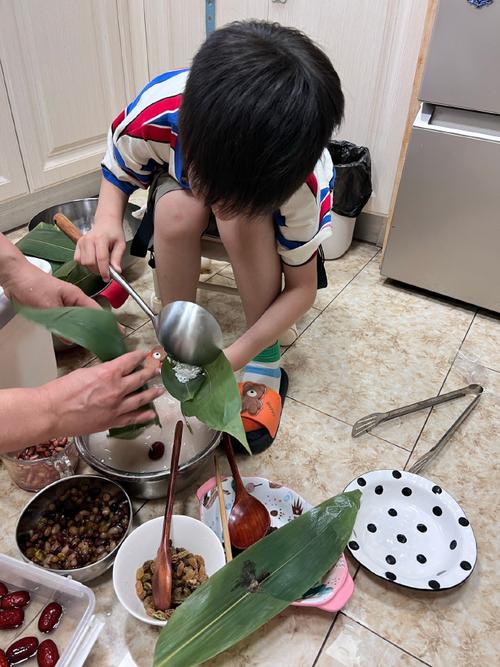 亲子一起包粽子满灶台撒米的家庭场景
