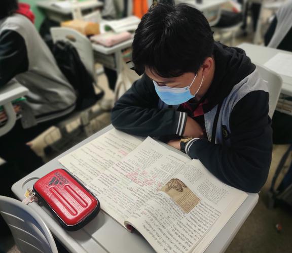 中学教室学生摊开名著摘抄本书桌