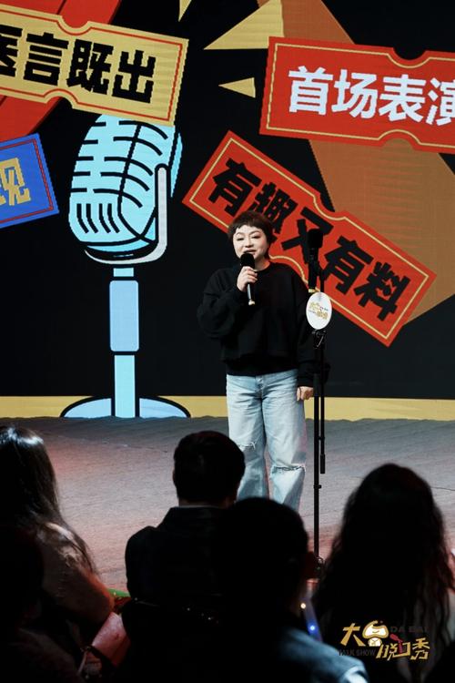 脱口秀表演者单手拿麦克风灯光下讲述