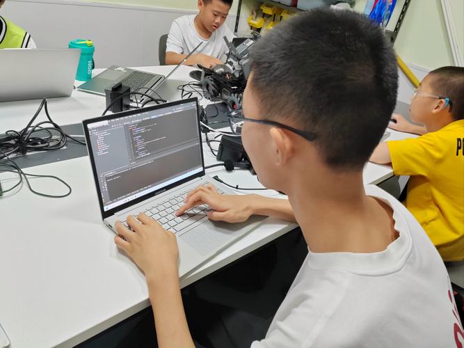 大学生在科技公司见习工位上学习编程
