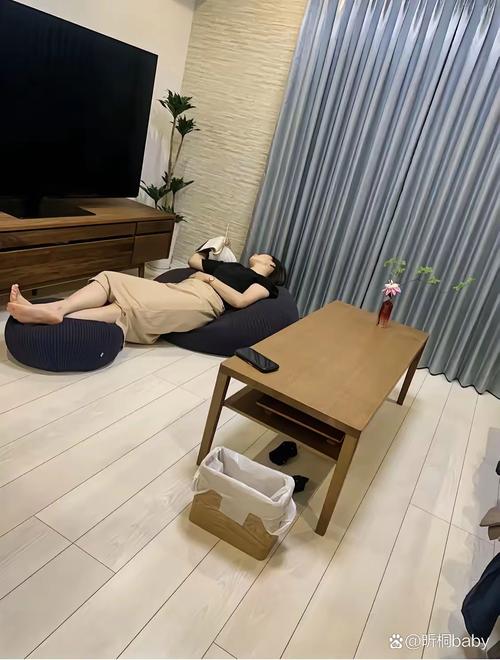 新手妈妈坐在客厅沙发背对孩子发呆实拍图