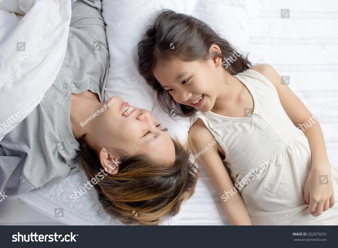 爸爸和女儿在床上玩枕头大战欢乐大笑