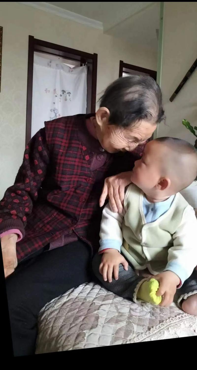 一位奶奶开心地给孙子读绘本，孩子依偎在奶奶怀里