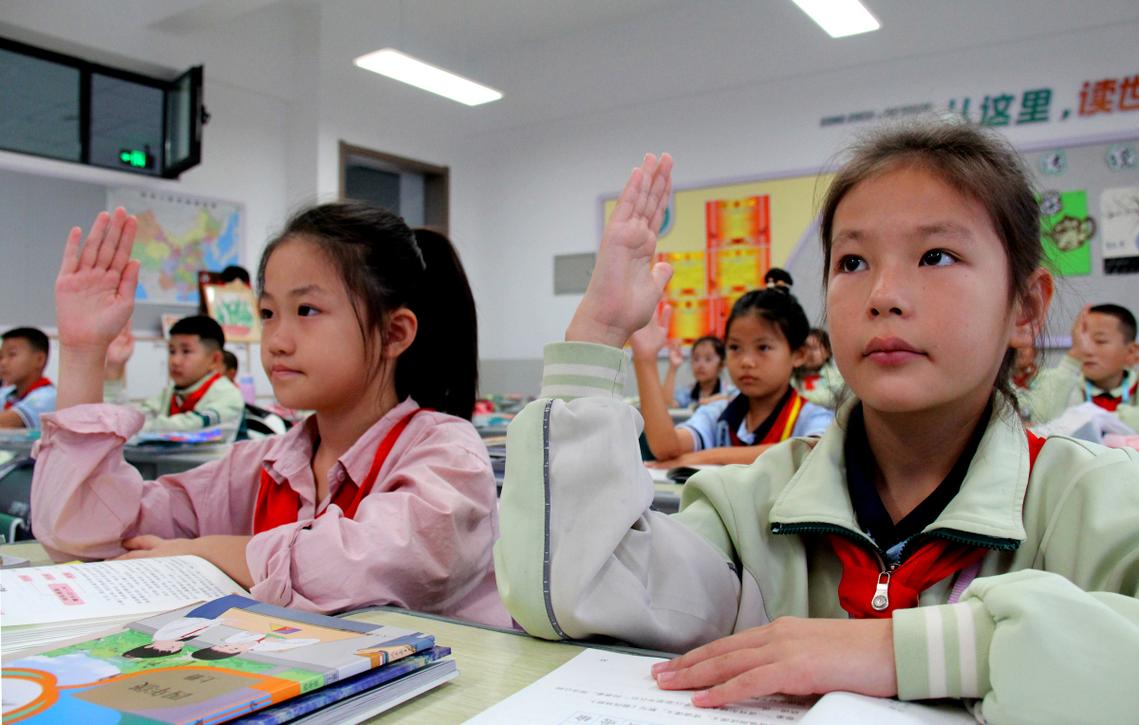 小学三年级课堂上学生举手发言的真实场景
