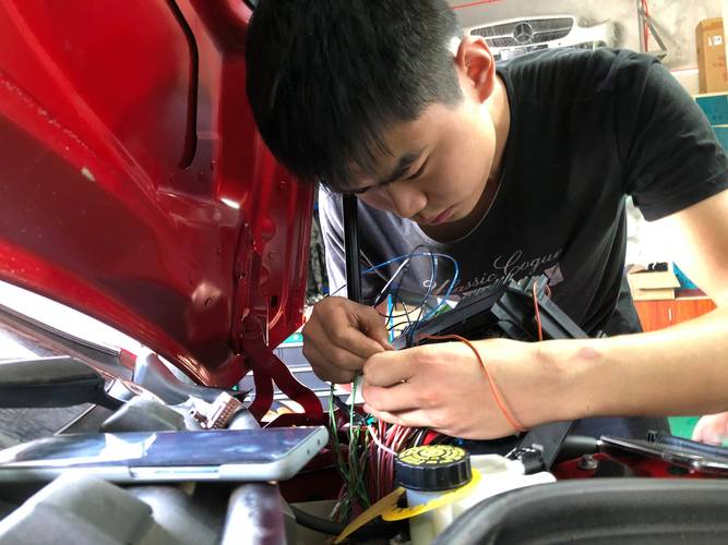 汽修师傅检查汽车大灯线路接头现场