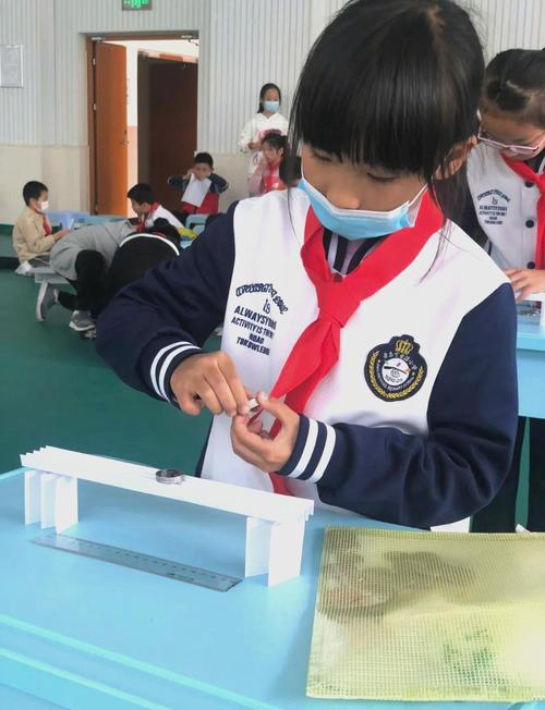 学生小组合作搭建纸桥承重测试场景