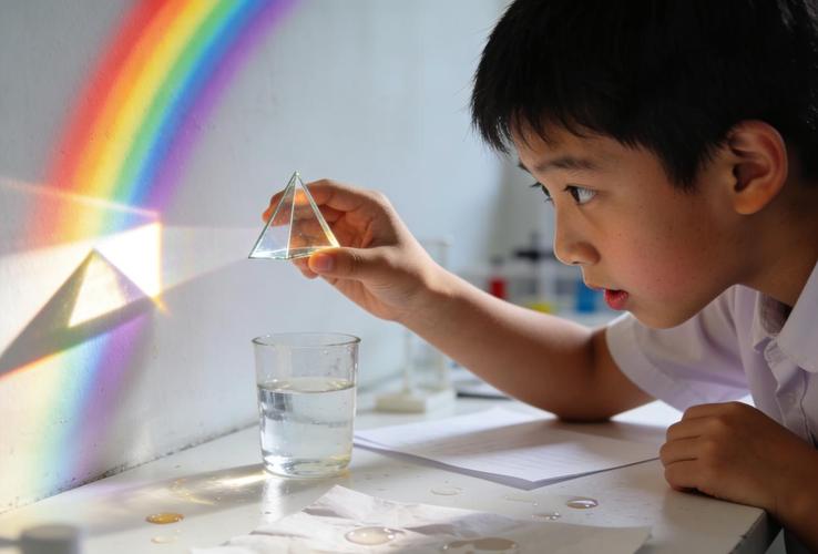 小学生在客厅白墙前举三棱镜调试找彩虹